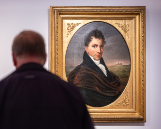 Bildnis von Bernhard August von Lindenau mit einer Persom in vordergrund, die sich das Gemälde anschaut