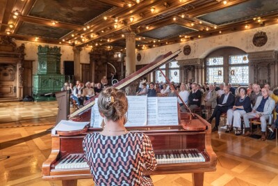 Eine Frau Spielt am Klavier im Bachsaal vor Publikum. 