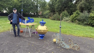 Klaus Hofmann mit einer Zeitkapsel vor der alten und neuen Wetterfahne.